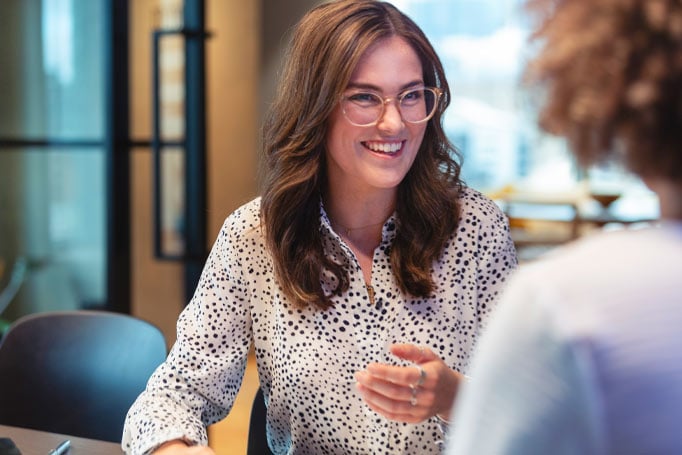Woman wearing glasses smiling at a customer
